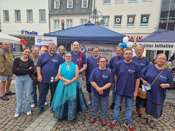 Viele Menschen in ähnlicher Kleidung vor dem Lebenshilfe Stand.