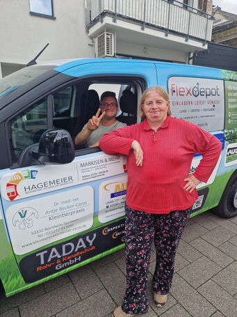 Ein junger Mann sitzt im neuen Wagen, eine Frau steht daneben.